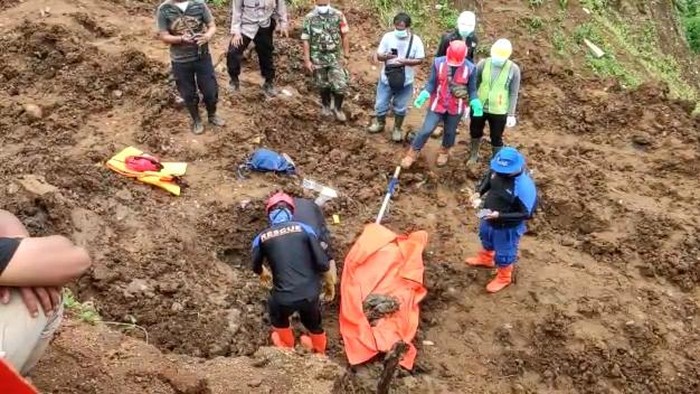 Petugas saat mengevakuasi kerangka manusia yang tertimbun longsor