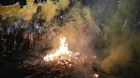 Selain berorasi, massa juga melakukan aksi bakar-bakar di jalanan. AP Photo/Ohad Zwigenberg.