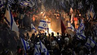 Warga Israel melakukan unjuk rasa setelah PM Benjamin Netanyahu memecat Menhan Yoav Gallant. Gallant dipecat sehari setelah dirinya memutuskan hubungan dengan pemerintah dan mendesak penghentian reformasi undang-undang yang kontroversial, Senin (27/3/2023). AP Photo/Ohad Zwigenberg.