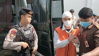 Ferry Irawan terlihat mengacungkan jari telunjuk saat digiring petugas masuk ke PN Kota Kediri. Dia mengangkat telunjuknya untuk awak media meminta wartawan menunggu statement-nya usia sidang. (Foto: Andhika Dwi/detikJatim)