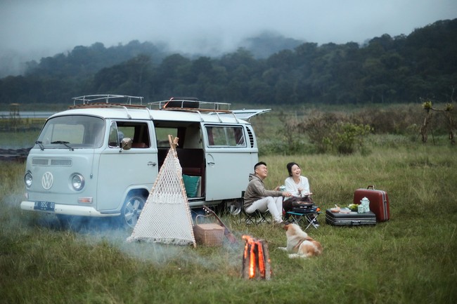 Tema camping bisa jadi pilihan untuk foto prewedding outdoor jika kamu dan pasangan hobi traveling dan berjiwa bebas. Tinggal siapkan properti sebagai focal point, misalnya mobil caravan atau tenda. Cukup pakai baju casual yang nyaman dikenakan. Foto: Weddingku/Danieliben Photography