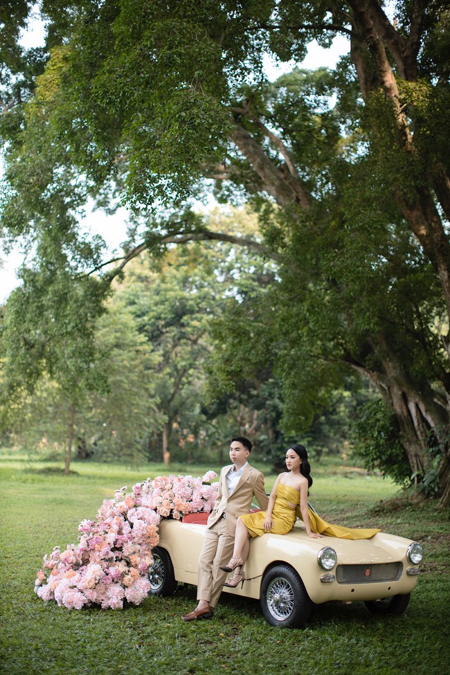 Pemotretan di taman atau hutan kota akan lebih unik dan menarik apabila kamu mengenakan sesuatu yang kontras. Misalnya saja mengenakan busana kuning dan properti mobil berwarna senada dengan latar belakang rumput serta pepohonan hijau. Foto: Weddingku/Danieliben Photography