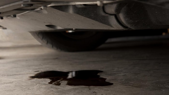 Oil leak or drop from engine of car on concrete floor , check and maintenance auto service