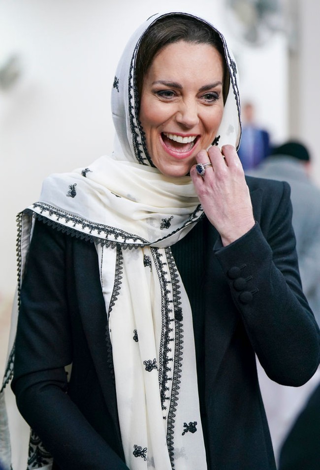 Kate Middleton tampil bersahaja dengan menutupi kepalanya menggunakan syal panjang putih berhias bordiran hitam. Syal tersebut merupakan koleksi dari brand asal Pakistan, Elan. Foto: Getty Images