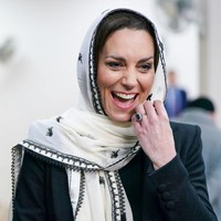 Kate Middleton tampil bersahaja dengan menutupi kepalanya menggunakan syal panjang putih berhias bordiran hitam. Syal tersebut merupakan koleksi dari brand asal Pakistan, Elan. Foto: Getty Images