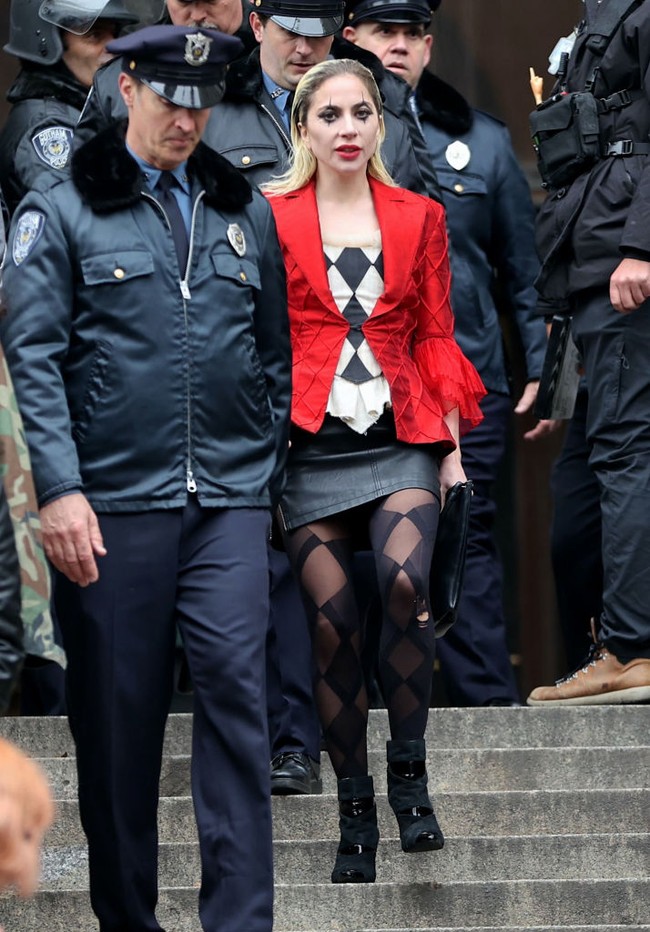 Penyanyi sekaligus aktris ini tampak mengenakan atasan motif wajik warna hitam-putih dipadu stocking, rok mini dan jaket merah. Foto: Getty Images