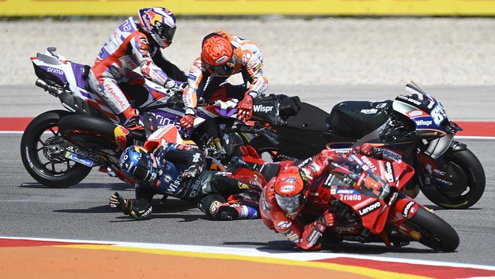 Honda Spanish rider Marc Marquez falls after crashing with Aprilia Portuguese rider Miguel Oliveira (out of frame) during the MotoGP race of the Portuguese Grand Prix at the Algarve International Circuit in Portimao, on March 26, 2023. (Photo by PATRICIA DE MELO MOREIRA / AFP) (Photo by PATRICIA DE MELO MOREIRA/AFP via Getty Images)