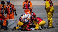 Sementara Oliveira sempat mendapat pertolongan marshal di trek. Marquez juga terlihat mendatanganinya untuk mengecek kondisi lawannya itu. (Foto: Steve Wobser/Getty Images)
