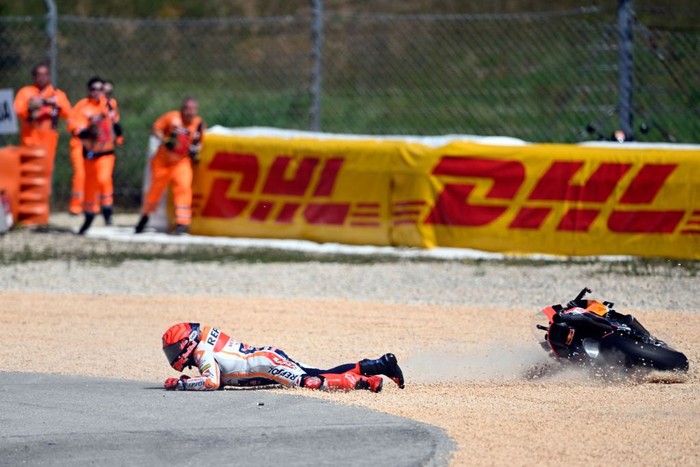 Honda Spanish rider Marc Marquez falls after crashing with Aprilia Portuguese rider Miguel Oliveira (out of frame) during the MotoGP race of the Portuguese Grand Prix at the Algarve International Circuit in Portimao, on March 26, 2023. (Photo by PATRICIA DE MELO MOREIRA / AFP) (Photo by PATRICIA DE MELO MOREIRA/AFP via Getty Images)