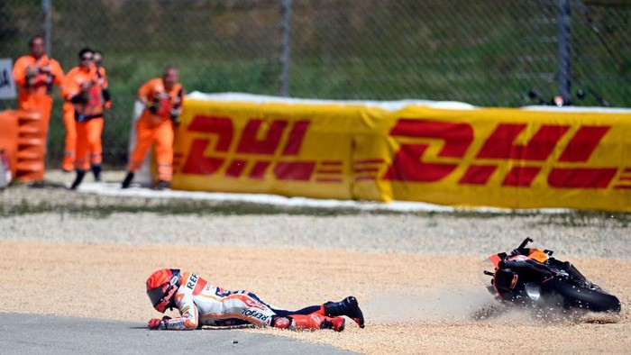Honda Spanish rider Marc Marquez falls after crashing with Aprilia Portuguese rider Miguel Oliveira (out of frame) during the MotoGP race of the Portuguese Grand Prix at the Algarve International Circuit in Portimao, on March 26, 2023. (Photo by PATRICIA DE MELO MOREIRA / AFP) (Photo by PATRICIA DE MELO MOREIRA/AFP via Getty Images)