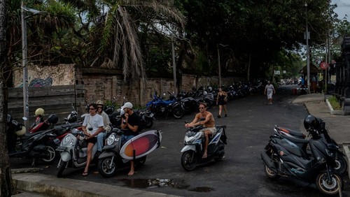 CANGGU, BALI, INDONESIA - MARCH 26: A foreigner tourist rides a motorcycle without helmet at a main road on March 26, 2023 in Canggu, Bali, Indonesia. Indonesian island of the gods plans to enact some rules for foreign tourists on operating motorcycles, scooters, and cars for travel around the island following a number of violations of traffic rules and bad behavior such as riding motorcycles without valid paperwork and helmets, driving recklessly, using fake Indonesian ID cards or abusing residence and work permits. (Photo by Agunng Parameswara/Getty Images)