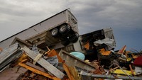 Terlihat mobil truk kontainer terbalik di atas puing-puing. Listrik yang seharusnya dinikmati 4.800 orang dilaporkan putus dan setidaknya 11 ribu rumah dan kawasan bisnis dalam kondisi gelap di Alabama.  
