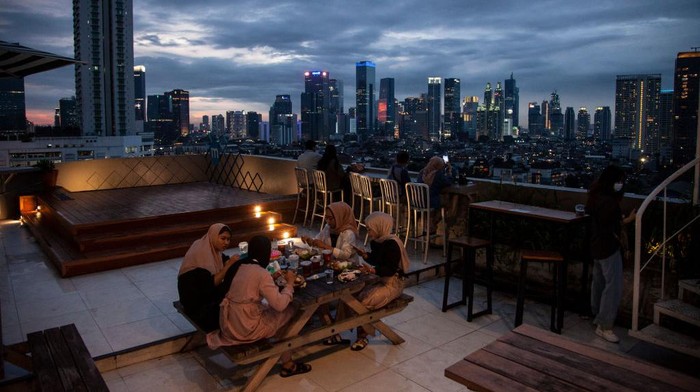 Indonesian Muslims break their fast at a cafe located on the roof top during the holy month of Ramadan in Jakarta , on March 26, 2023. (Photo by Aditya Irawan/NurPhoto via Getty Images)