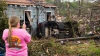 Seorang warga mengambil foto mobil dan rumahnya yang hancur imbas tornado yang mengantam kawasan Georgia.  