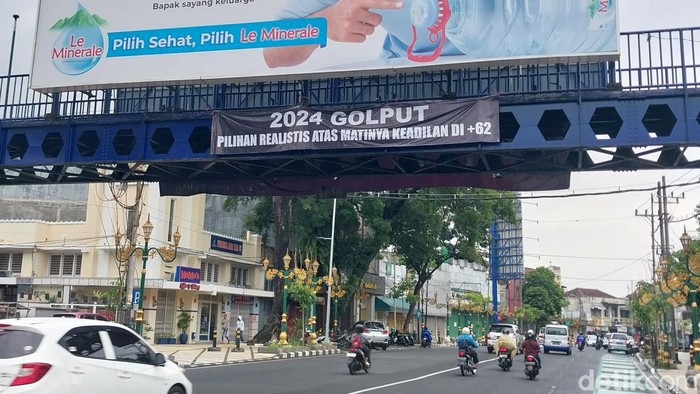 Spanduk 2024 golput yang terpasang di JPO Jalan Basuk Rahmat, Kayutangan, Kota Malang.