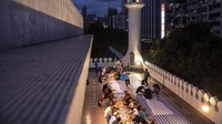 Orang-orang menikmati menu berbuka puasa yang dihidangkan pihak masjid.  