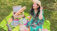Walaupun hanya piknik di halaman rumah tetapi momen ini menjadi waktu bersantai untuknya. Ada roti dan buah-buahan disediakan sebagai bekal piknik. Foto: Instagram/tasyakamila
