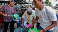 Umat Islam mengambil bubur pedas yang dibagikan kepada orang-orang untuk berbuka puasa yang tersedia di Masjid Raya Al-Mashun, Medan, Kamis (23/3/2023).  