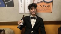 Saat berada di Tokyo, anak laki-laki pedangdut Iis Dahlia sepertinya sedang menikmati satu botol mimuman. Kira-kira minuman apa ya? Foto: Instagram @iamdevano