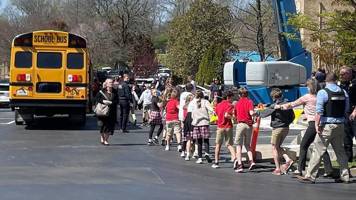 Horor Penembakan Massal di SD Nashville AS, 3 Anak Tewas Children from The Covenant School, a private Christian school in Nashville, Tenn., hold hands as they are taken to a reunification site at the Woodmont Baptist Church after a deadly shooting at their school on Monday, March 27, 2023. (AP Photo/Jonathan Mattise)
