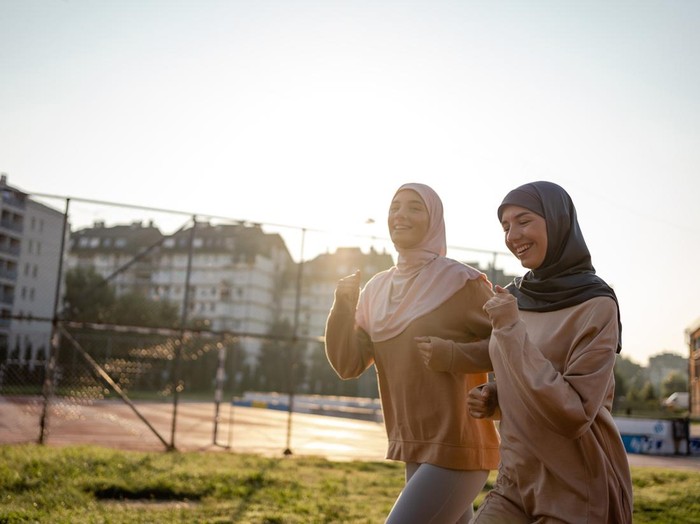 Muslim sporty women with hijab are jogging outdoors.