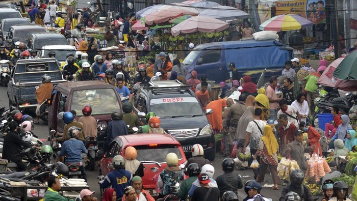 Sejumlah kendaraan terhambat akibat pasar tumpah Pasir Gintung di Jalan Imam Bonjol Bandar Lampung, Lampung, Selasa (28/3/2023). Para pedagang pasar tumpah tersebut menutup setengah badan jalan dan menyebabkan arus lalu lintas tersendat dan mengakibatkan kemacetan pada jam sibuk. ANTARA FOTO/Ardiansyah/aww.