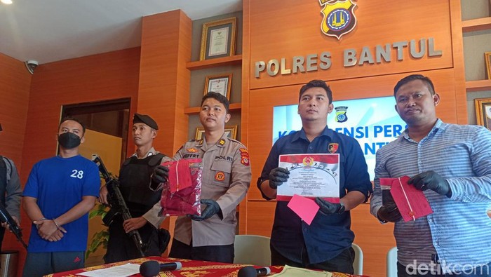 Polisi saat menunjukkan barang bukti tindak kejahatan AS. Tampak pula AS tertunduk lesu saat dihadirkan di Polres Bantul, Selasa (28/3/2023).