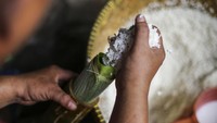 Pekerja melakukan proses pembuatan lemang dengan mengisi beras ketan ke dalam bambu di kawasan Senen, Jakarta, Selasa (28/3/2023).