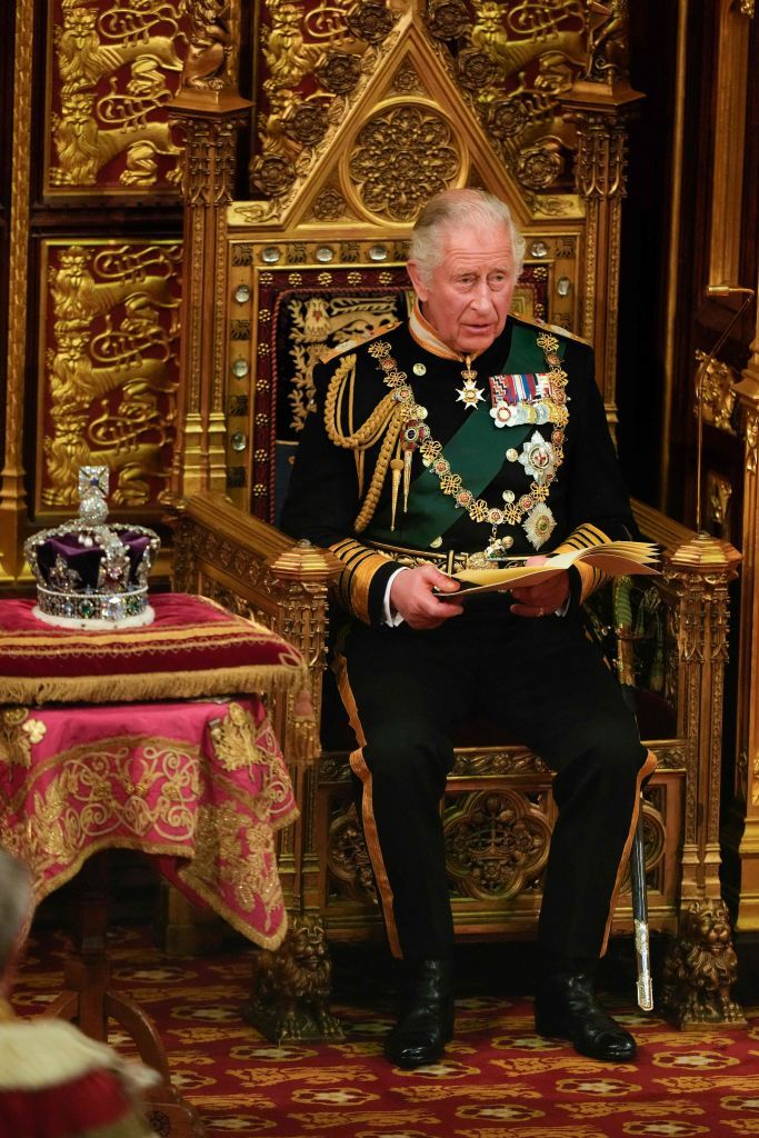 Raja Charles III Britain's Prince Charles, Prince of Wales (R) sits by the The Imperial State Crown (L) in the House of Lords Chamber during the State Opening of Parliament at the Houses of Parliament, in London, on May 10, 2022. - Queen Elizabeth II will miss Tuesday's ceremonial opening of Britain's parliament, as Prime Minister Boris Johnson tries to reinvigorate his faltering government by unveiling its plans for the coming year. (Photo by Alastair Grant / POOL / AFP) (Photo by ALASTAIR GRANT/POOL/AFP via Getty Images)