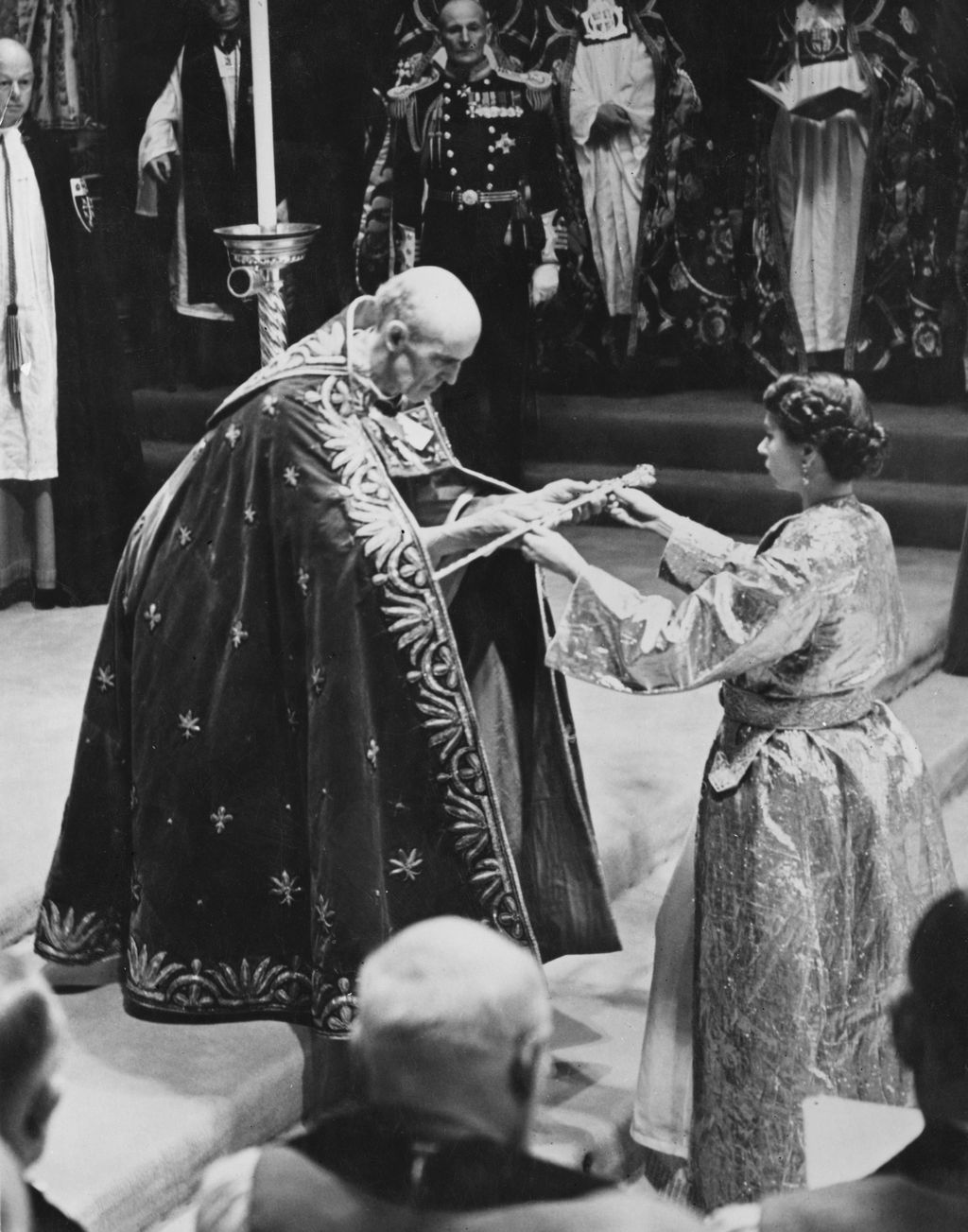 Ratu Elizabeth II Pakai Jubah Emas saat Penobatan The coronation of Queen Elizabeth II in Westminster Abbey, London, 2nd June 1953. The Archbishop of Canterbury, Geoffrey Fisher, presents the Queen with the Sceptre with the Cross. (Photo by Topical Press Agency/Hulton Archive/Getty Images)