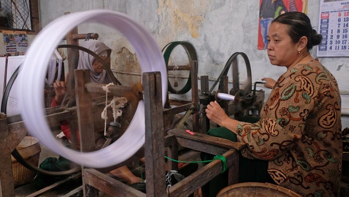 Pekerja menjemur sarung Goyor di industri sarung menggunakan ATBM (Alat tenun bukan mesin) cap Botol Terbang kelurahan Potrobangsan, Magelang, Jawa Tengah, Selasa (28/3/2023). Menurut perajin saat ini produksi sarung Goyor kembali normal setelah hampir tiga tahun terdampak pandemi COVID-19, dan dipasarkan ke berbagai daerah di Indonesia dan negara-negara kawasan Timur Tengah dengan harga jual Rp700 ribu per lembar. ANTARA FOTO/Anis Efizudin/foc.