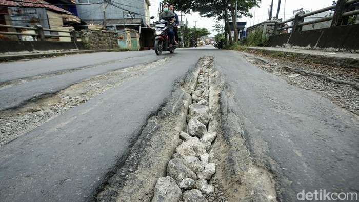 Pengendara yang melintas di Jembatan Kali Ulu Cikarang, Cikarang, harap berhati-hati, Rabu (23/3). Jalan di atas jembatan itu mengalami kerusahan.