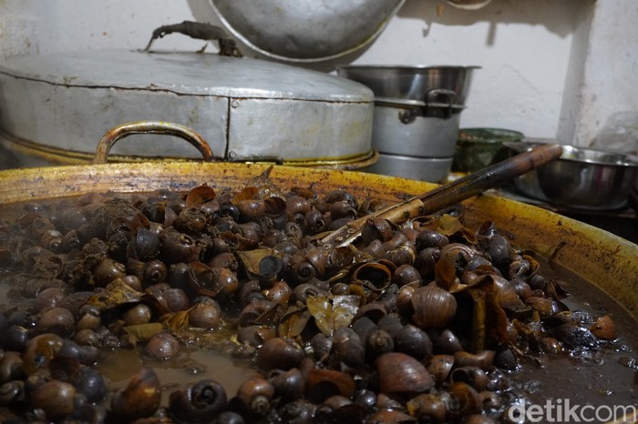 Chamlani (63) mengolah masakan keong khas bulan Ramadan di kediamannya jalan Kauman Lama, Purwokerto Timur, Kabupaten Banyumas, Rabu (29/3/2023).