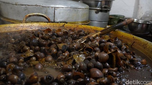 Chamlani (63) mengolah masakan keong khas bulan Ramadan di kediamannya jalan Kauman Lama, Purwokerto Timur, Kabupaten Banyumas, Rabu (29/3/2023).