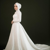 Gaun dengan ekor menyapu lantai merupakan gaya klasik pengantin yang tak pernah lekang waktu. Model ini juga bisa diterapkan untuk pengantin hijab. Foto: Weddingku/ Ivory Bridal