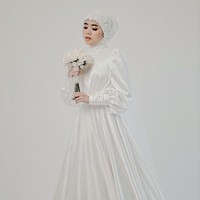 Gaun satin dengan lengan puff cocok untuk pengantin hijab yang ingin mengenakan busana simpel tapi tetap menonjolkan keindahan. Aksen lace pada jilbab dan leher menambah kesan feminin. Foto: Weddingku/ Ivory Bridal