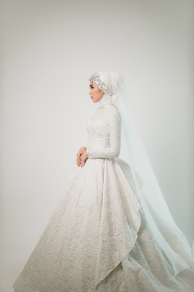 Tak harus selalu full-payet untuk terlihat mewah. Detail bordir dan lace pada keseluruhan busana pun membuat penampilan pengantin hijab tampak glamor. Foto: Weddingku/ Ivory Bridal
