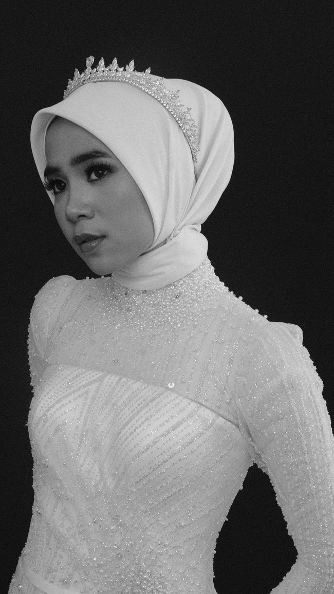 Hijab simpel bisa tampil lebih glamor dengan tambahan tiara berhias kristal. Gaya ini bisa kamu terapkan untuk acara akad nikah maupun resepsi pernikahan. Foto: Weddingku/ Ivory Bridal