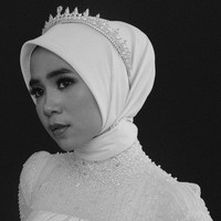 Hijab simpel bisa tampil lebih glamor dengan tambahan tiara berhias kristal. Gaya ini bisa kamu terapkan untuk acara akad nikah maupun resepsi pernikahan. Foto: Weddingku/ Ivory Bridal