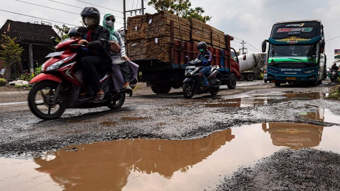 JALAN RUSAK DI JALUR TENGAH SEMARANG-GROBOGAN Pengendara sepeda motor melintas di antara jalan berlubang yang tergenang air di Jalan Raya Semarang-Purwodadi Km 23, Kabupaten Demak, Jawa Tengah, Rabu (29/3/2023). Sejumlah titik jalur tengah yang menghubungkan Kota Semarang-Kabupaten Grobogan-Kabupaten Blora itu mengalami kerusakan karena hujan dan beban kendaraan sehingga membahayakan keselamatan para pengendara yang melintas. ANTARA FOTO/Aji Styawan/tom.