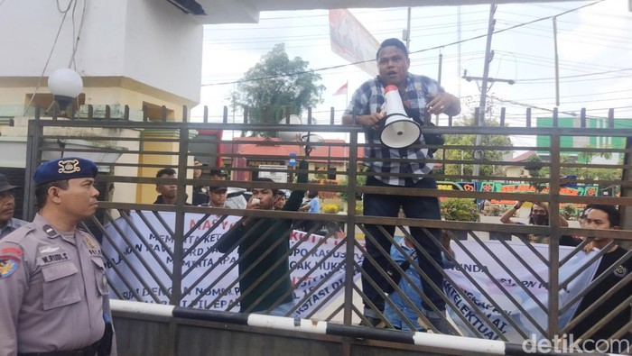 Massa aksi memanjat pagar gedung DPRD Kota Tanjungbalai meminta pembantalan pelantikan PAW Mukmin Mulyadi.