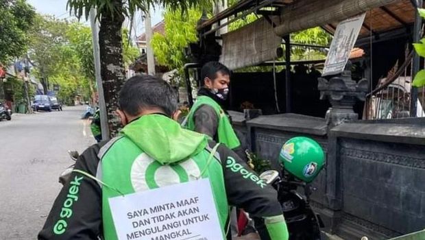 Belasan pengemudi ojek online menyapu di pinggir jalan, sebagai sanksi mangkal di sembarang tempat di Canggu, Badung.