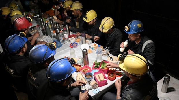 Penambang berbuka puasa (buka puasa) di lokasi tambang, salah satu pusat produksi batu bara lignit utama Turkiye, selama bulan suci Ramadhan di distrik Soma Manisa, Turkiye pada 25 Maret 2023. Sekitar 500 penambang di perusahaan tambang kembali ke lokasi tambang pada setelah berpartisipasi dalam operasi pencarian dan penyelamatan menyusul gempa berkekuatan 7,7 dan 7,6 yang melanda beberapa provinsi Turkiye terjadi pada 06 Februari. Para penambang, yang bekerja ratusan meter di bawah lokasi sesuai dengan shift mereka, juga memenuhi persyaratan bulan suci. Ramadhan meskipun profesi mereka sulit. Menurut jam kerja mereka, mereka menghabiskan waktu berbuka puasa dan sahur bersama. (Mahmut Serdar Alakus/Anadolu Agency via Getty Images)