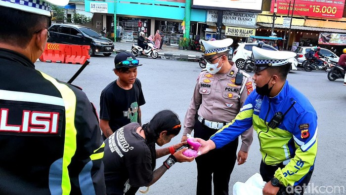 Polisi di Karawang saat membagikan takjil kepada warga, Rabu (29/3/2023).