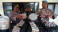 Personel kepolisian dan TNI menunjukkan petasan dan bahan baku petasan yang berhasil disita, di Polsek Tegal Barat, Tegal, Jawa Tengah.