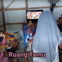 Masuk ke dalam rumah langsung disambut dengan ruang tamu yang juga terlihat sederhana. Ruang tamu tersebut tampak dilengkapi dengan beberapa sofa dan sebuah meja kayu serta televisi. Foto: YouTube/Daily Indah
