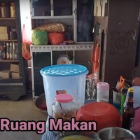 Di bagian dalam rumah terdapat ruang makan yang juga sederhana. Ruang makan tersebut tampak dipenuhi dengan barang-barang dan makanan. Foto: YouTube/Daily Indah