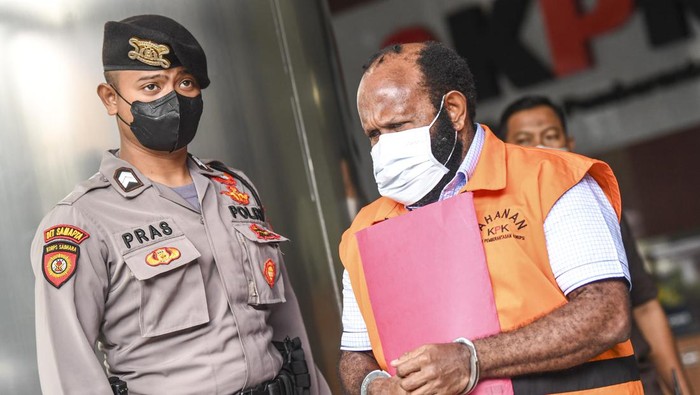Tangan Diborgol dan Berbaju Orange, Ricky Ham Pagawak Jalani Pemeriksaan KPK Tersangka kasus dugaan suap dan gratifikasi, Bupati Nonaktif Mamberamo Tengah Ricky Ham Pagawak (kanan) berjalan usai menjalani pemeriksaan di Gedung Merah Putih KPK, Jakarta, Rabu (29/3/2023). Ricky menjalani pemeriksaan terkait kasus dugaan suap dan gratifikasi sejumlah pengerjaan proyek di Mamberamo Tengah selama 2013-2019 serta kasus tindak pidana pencucian uang (TPPU) yang nilainya mencapai Rp200 miliiar.