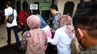 AG menutupi wajahnya dengan jaket berwarna biru.
