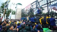 Sejumlah mahasiswa tampak memanjat pagar gedung DPR.